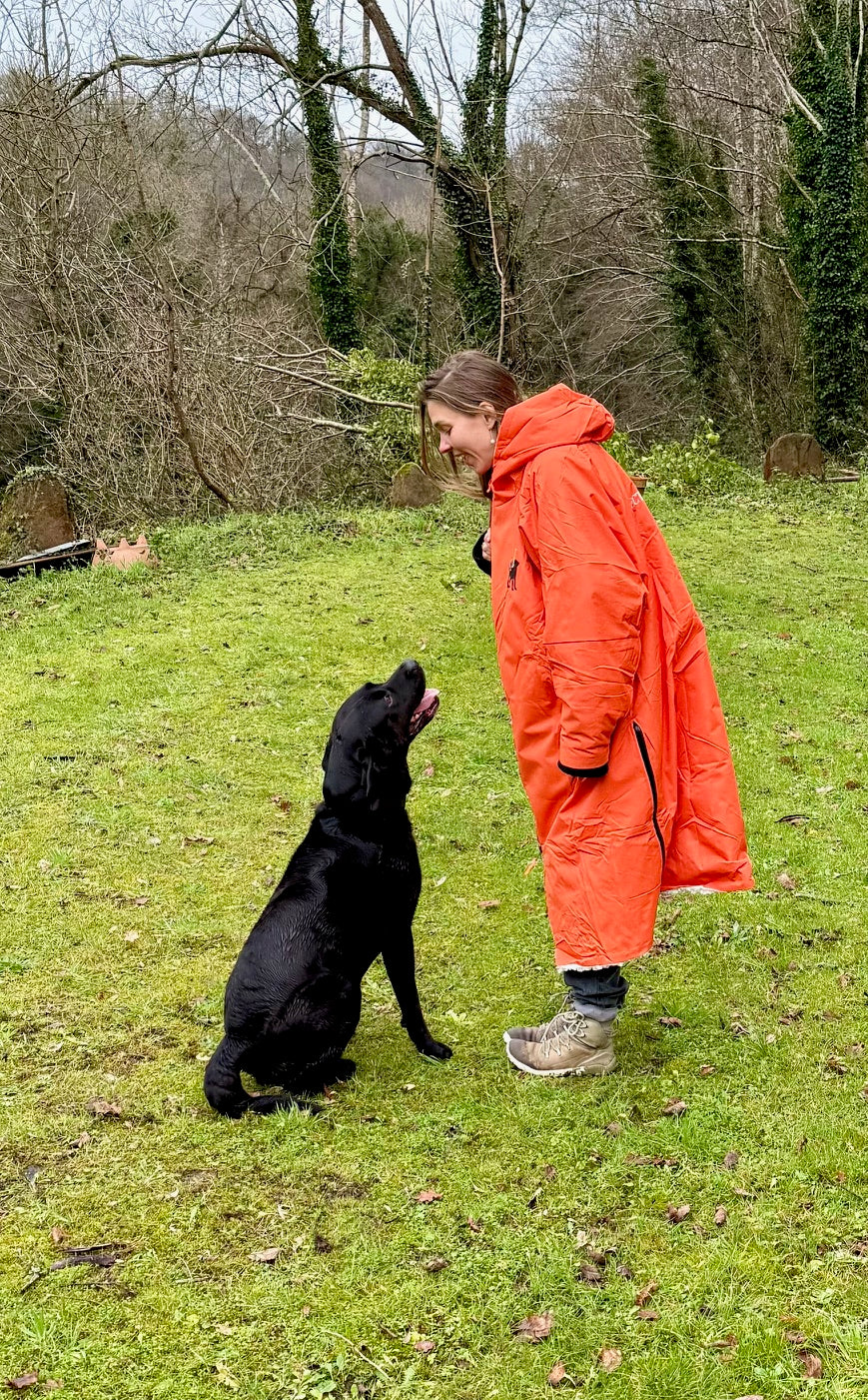 “Woman walking her dog in the Hector & George fleece-lined waterproof coat – best dog walking coat UK.”
