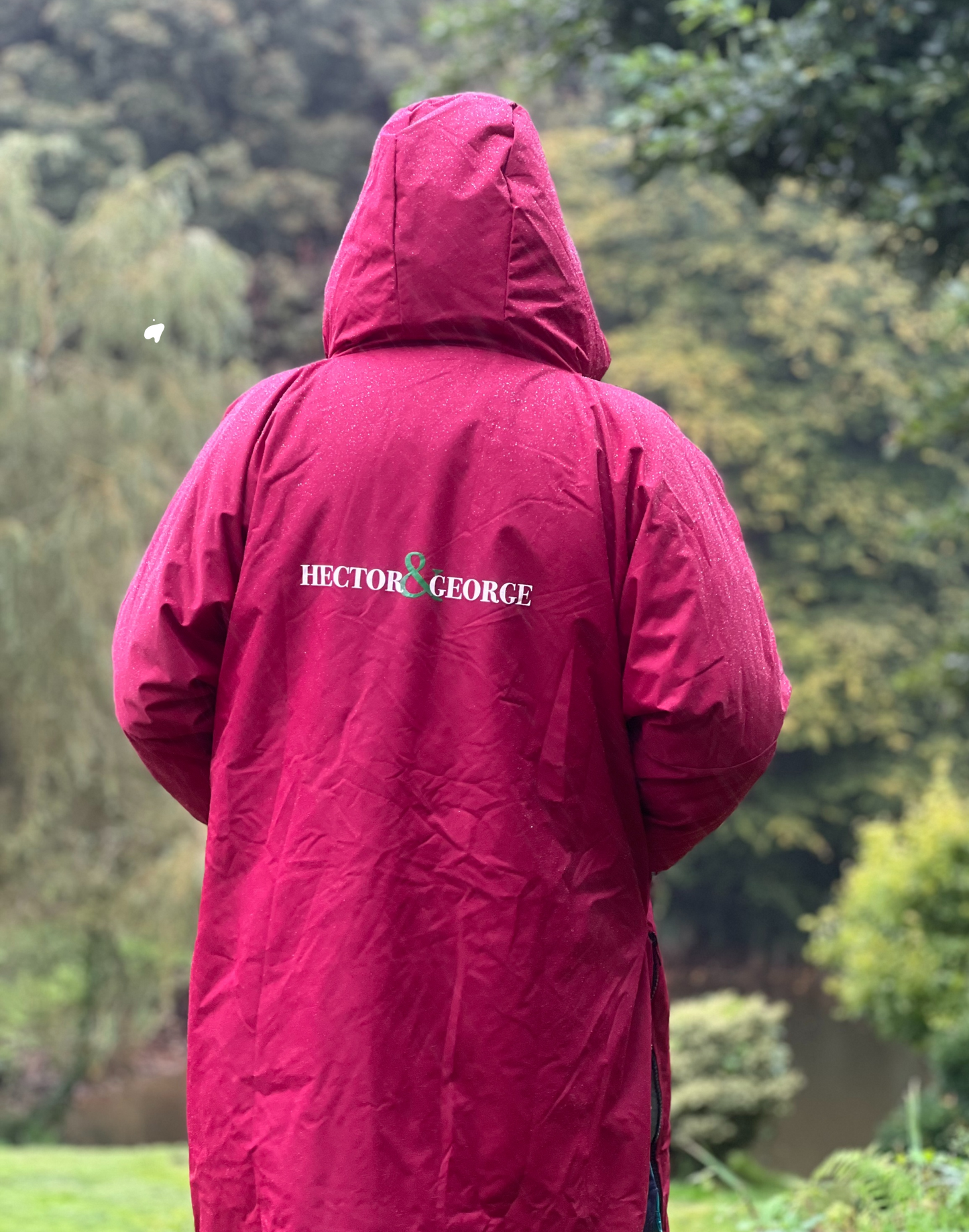 Long burgundy waterproof dog walking coat in British countryside