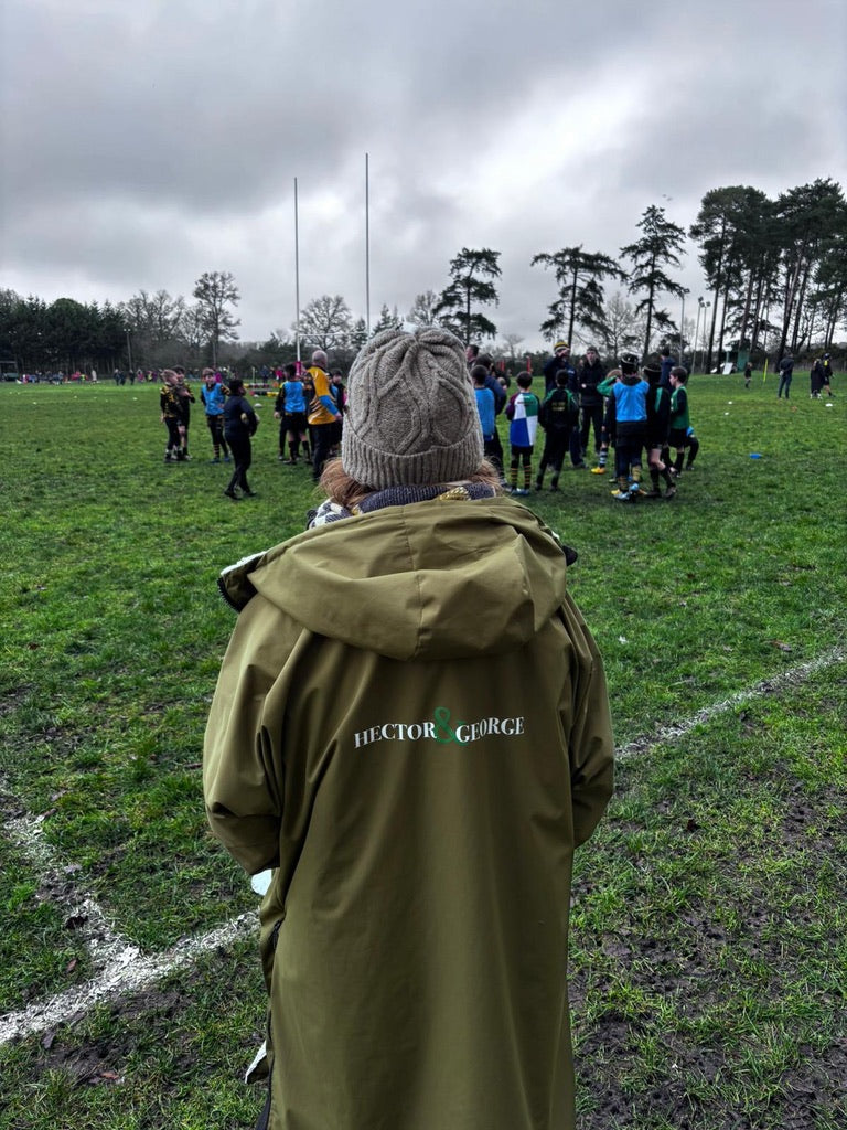 “woman wearing long waterproof coat on football touchline UK”