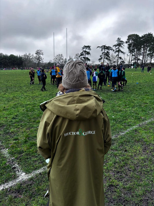 “woman wearing long waterproof coat on football touchline UK”